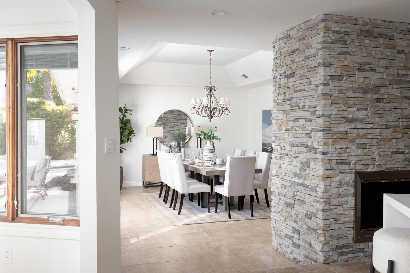Staged dining room Poway stone fireplace chandelier